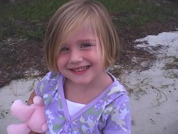 My daughter, behind the house on the bay.